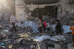 Fotografía de archivo, tomada el 22/05/2025, que muestra a palestinos caminando sobre un edificio destruido en Gaza por ataques israelíes. EFE/EPA/MOHAMMED SABER