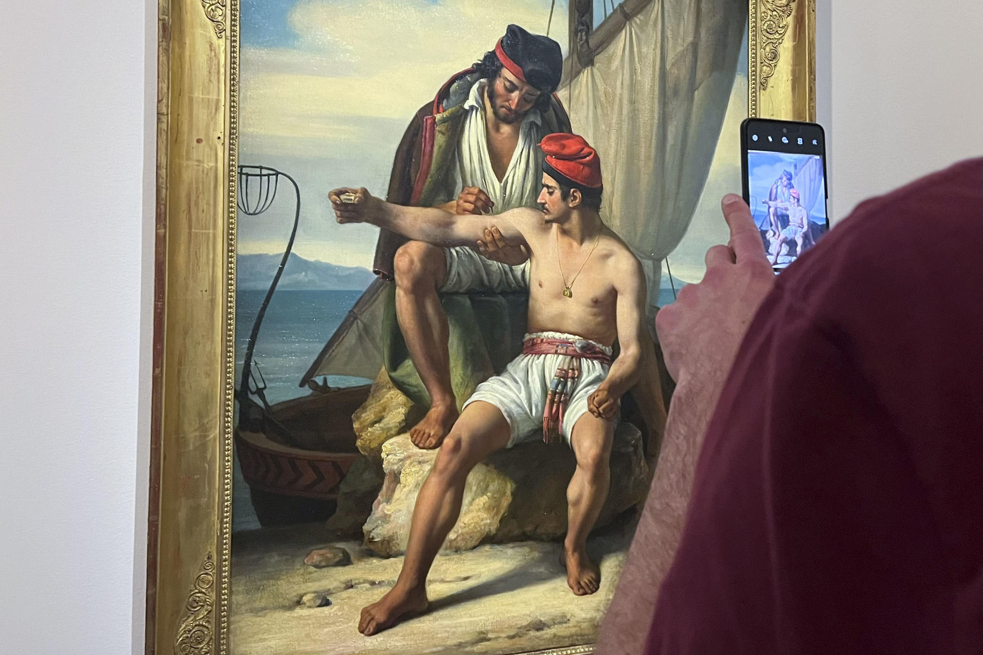 Vista de la pintura de Constantin Jean Marie Prévost, 'El tatuaje del marinero' (1830), que demuestra el valor histórico de los tatuajes como práctica cultural y de pertenencia en diferentes comunidades a lo largo del tiempo, según muestra la nueva exposición en el centro Vieille Charité de Marsella. El arte del tatuaje, tradicionalmente denostado por estar asociado a las clases más bajas y pueblos aborígenes, pasa de la piel a la galería en una exposición de Museos de Marsella que propone redescubrir el poder identitario de esta práctica y su relación con la historia del arte. EFE/Val Torres