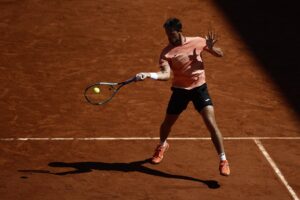 El argentino Mariano Navone devuelve una bola durante su partido ante el italiano Lorenzo Musetti, en la tercera ronda de Roland Garros. EFE/EPA/YOAN VALAT