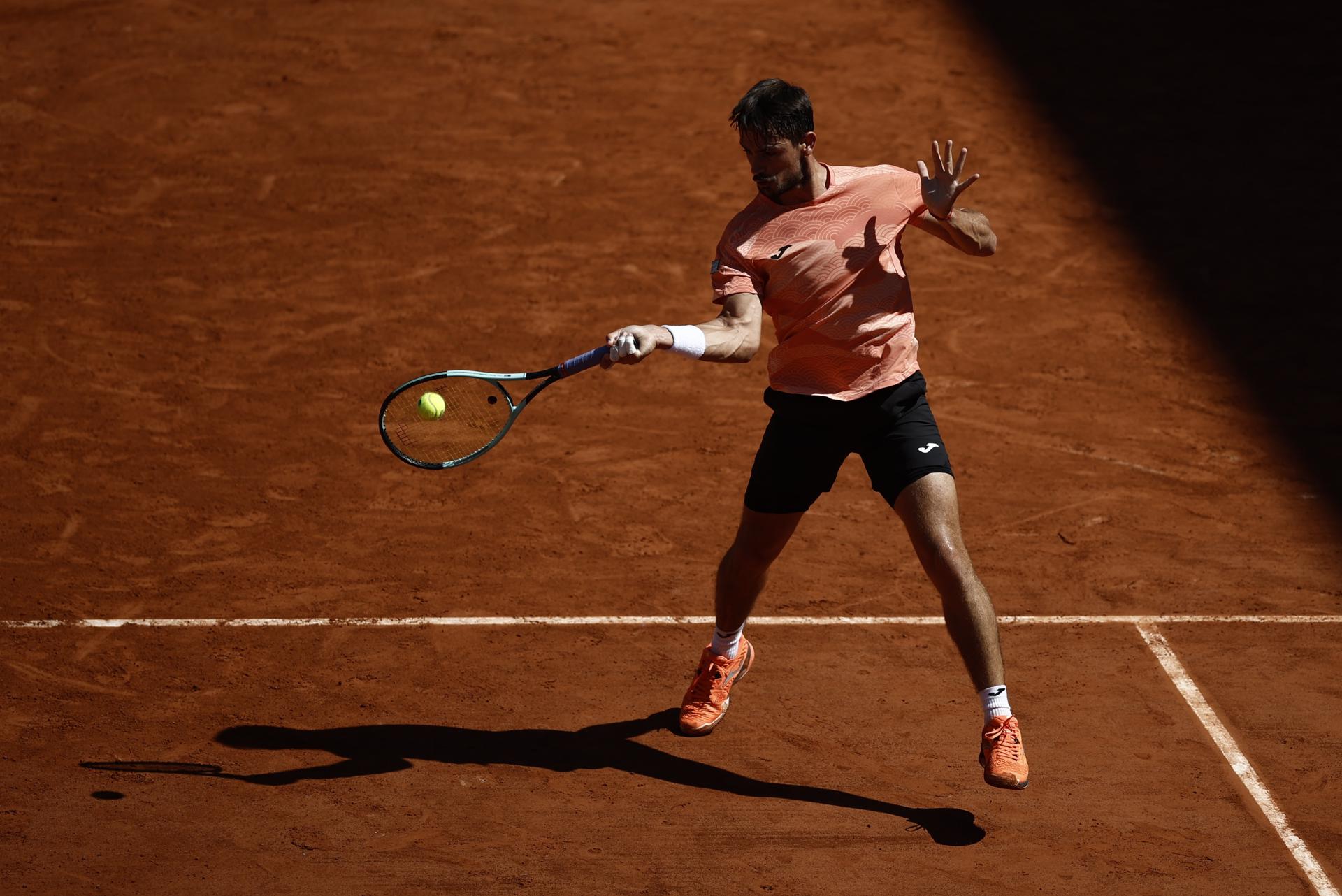 El argentino Mariano Navone devuelve una bola durante su partido ante el italiano Lorenzo Musetti, en la tercera ronda de Roland Garros. EFE/EPA/YOAN VALAT