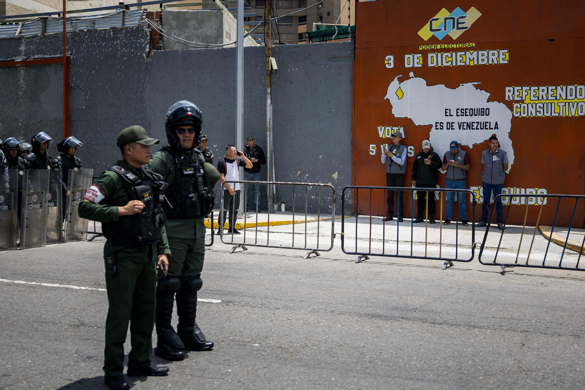 Fotografía de militares custodiando las instalaciones del Consejo Nacional Electoral (CNE) junto a un mapa alegórico al territorio del Esequibo, en Caracas (Venezuela). EFE/ Miguel Gutiérrez
