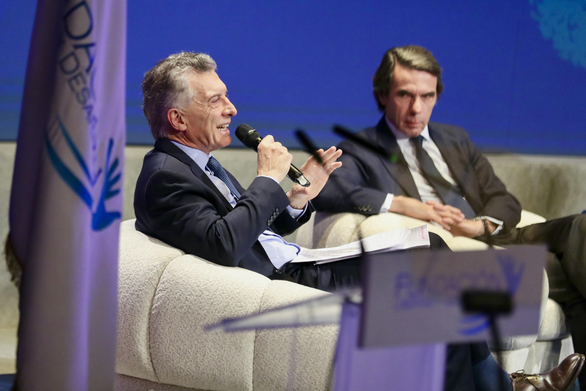 El expresidente del gobierno de España José María Aznar (d), junto al ex presidente argentino Mauricio Macri (i), durante el encuentro que se celebra este jueves en el teatro Campoamor de Oviedo para analizar el escenario de guerra comercial, la evolución de la ciberseguridad y los riesgos que conlleva la inteligencia artificial, en un encuentro organizado por la Fundación Libertad y Desarrollo. EFE/ J.L.Cereijido.