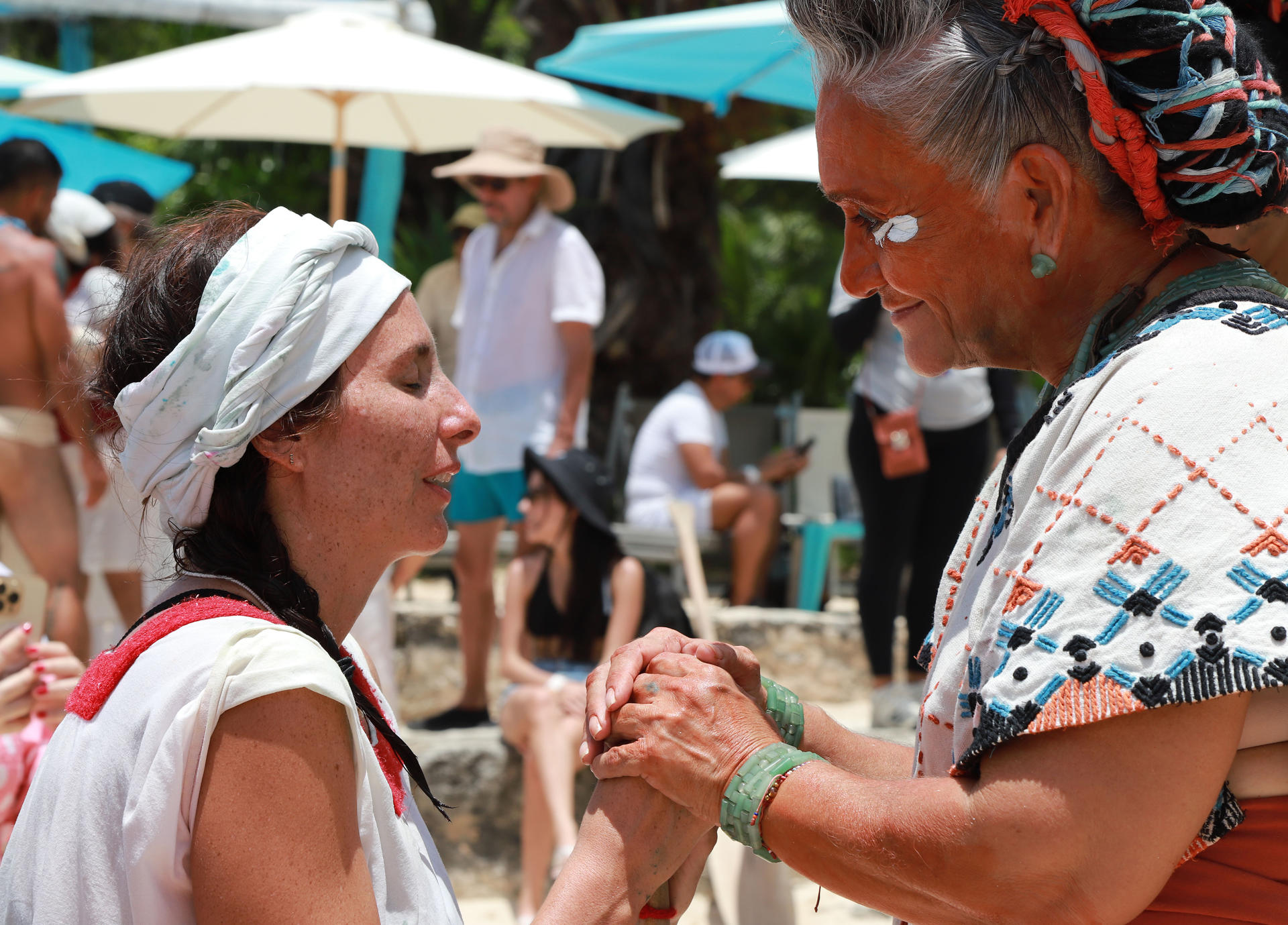 Personas participan en un ritual en la 'Travesía Sagrada' este domingo, en la Playa del Carmen, en Quintana Roo (México). EFE/Lourdes Cruz