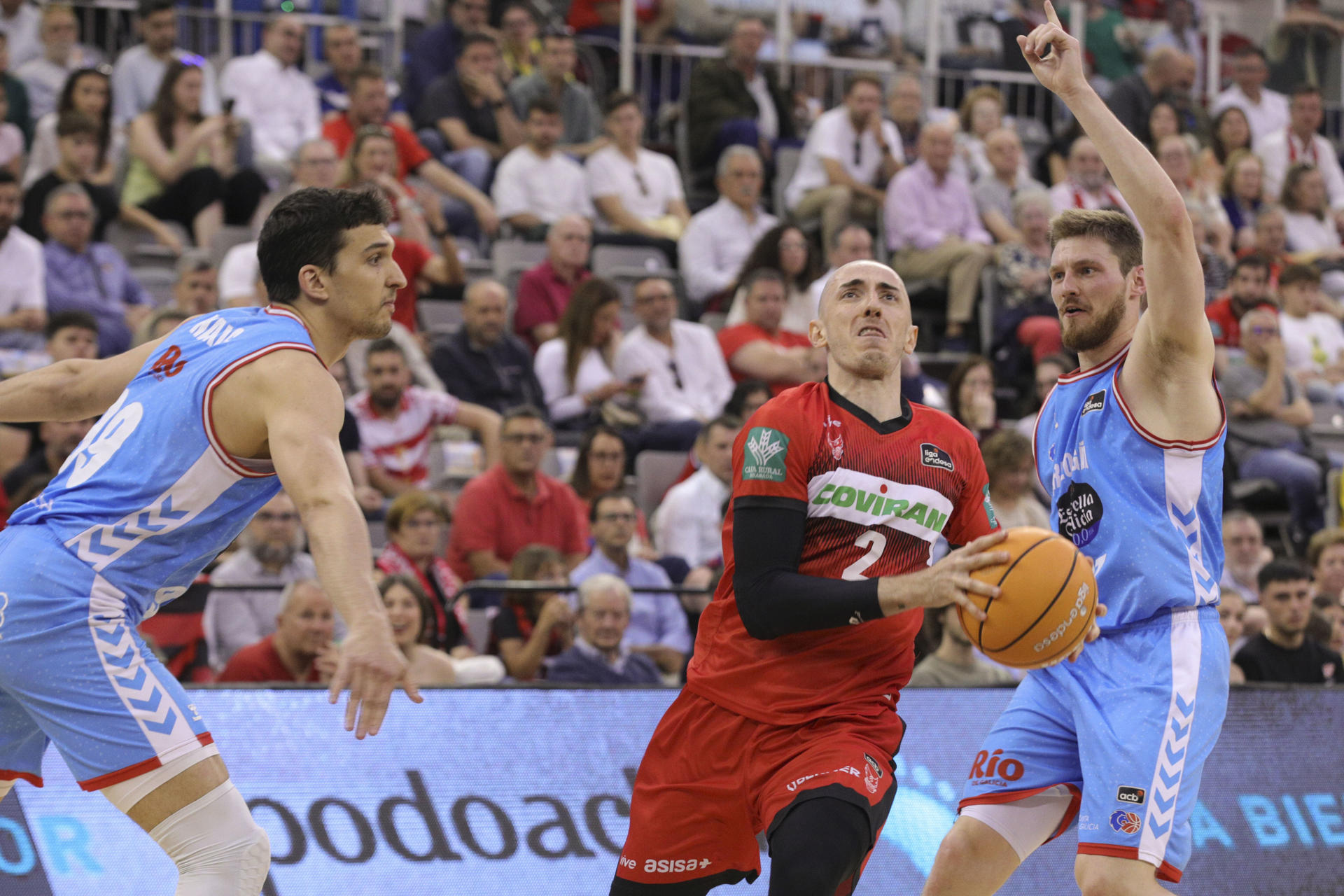 El base francés del Covirán Jonathan Rousselle (c) se escapa de Artur Kuruks (d) y de Toni Nakic (i), ambos de Río Breogán, durante el partido de Liga Endesa que enfrenta a los equipos de Covirán Granada y Río Breogán, en el Palacio de Deportes de Granada. EFE/Pepe Torres.