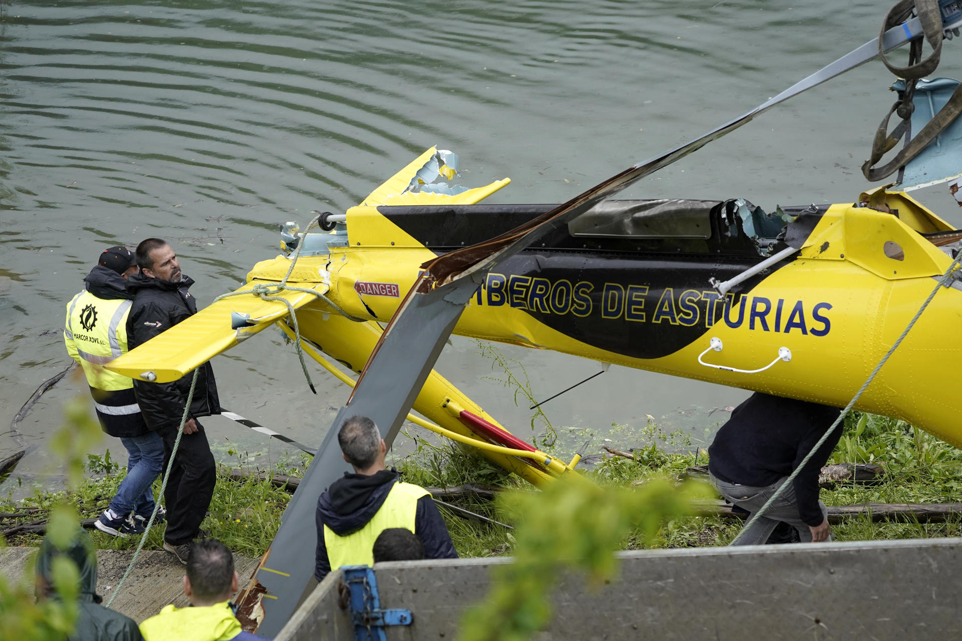 Un equipo de buzos se ha encargado de reflotar este domingo el helicóptero de Bomberos de Asturias que el viernes se precipitó al embalse de Tanes al tropezar con un tendido eléctrico la estructura que llevaba colgada para sacar agua destinada a las tareas de extinción de un incendio forestal cercano. El helicóptero se encontraba boca abajo a diez metros de profundidad en la cabecera de este embalse, destinado al abastecimiento de agua potable a cientos de miles de personas del área central de Asturias. EFE/ Paco Paredes