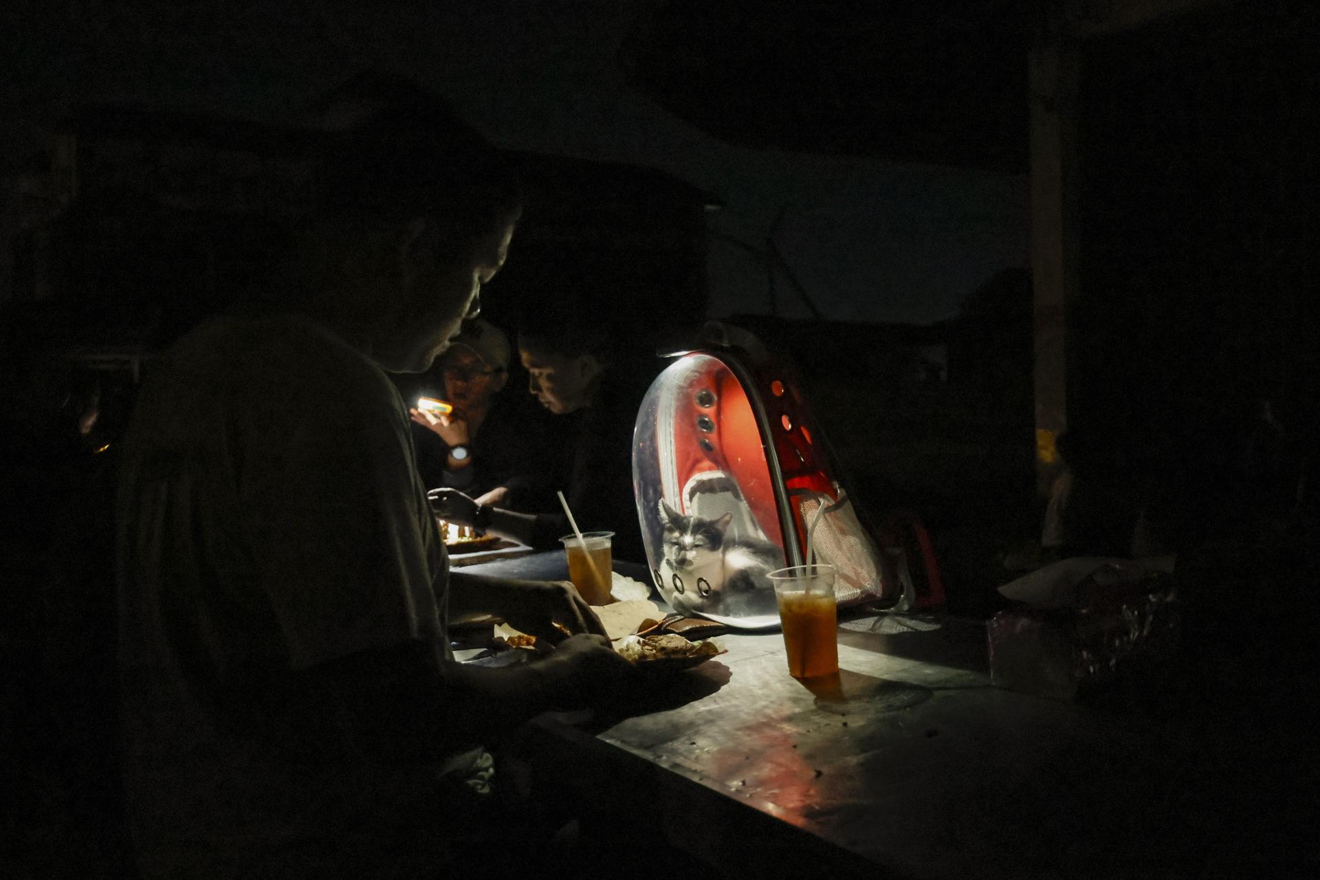 DENPASAR (Indonesia), 02/05/2025.- People use mobile phone light during a power outage in Bali, Indonesia, 02 May 2025. The island of Bali experienced a total power outage or blackout on Friday, 02 May 2025, at around 4:00 PM due to a disruption in the undersea cable that transmits electricity from Java to Bali, according to officials. EFE/EPA/MADE NAGI