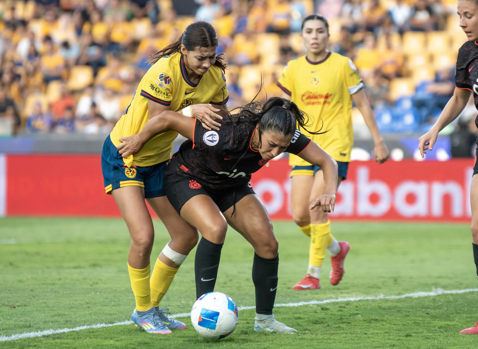 La delantera de América Montserrat Saldivar (i) cubre con su cuerpo el balón del asedio de la defensora de Portland Thorns Reyna Reyes durante el partido por el tercer puesto de la Copa de Campeones de la Concacaf que ganó este sábado por 0-3 el equipo estadounidense en el Estadio Universitario de Monterrey. EFE/ Miguel Sierra