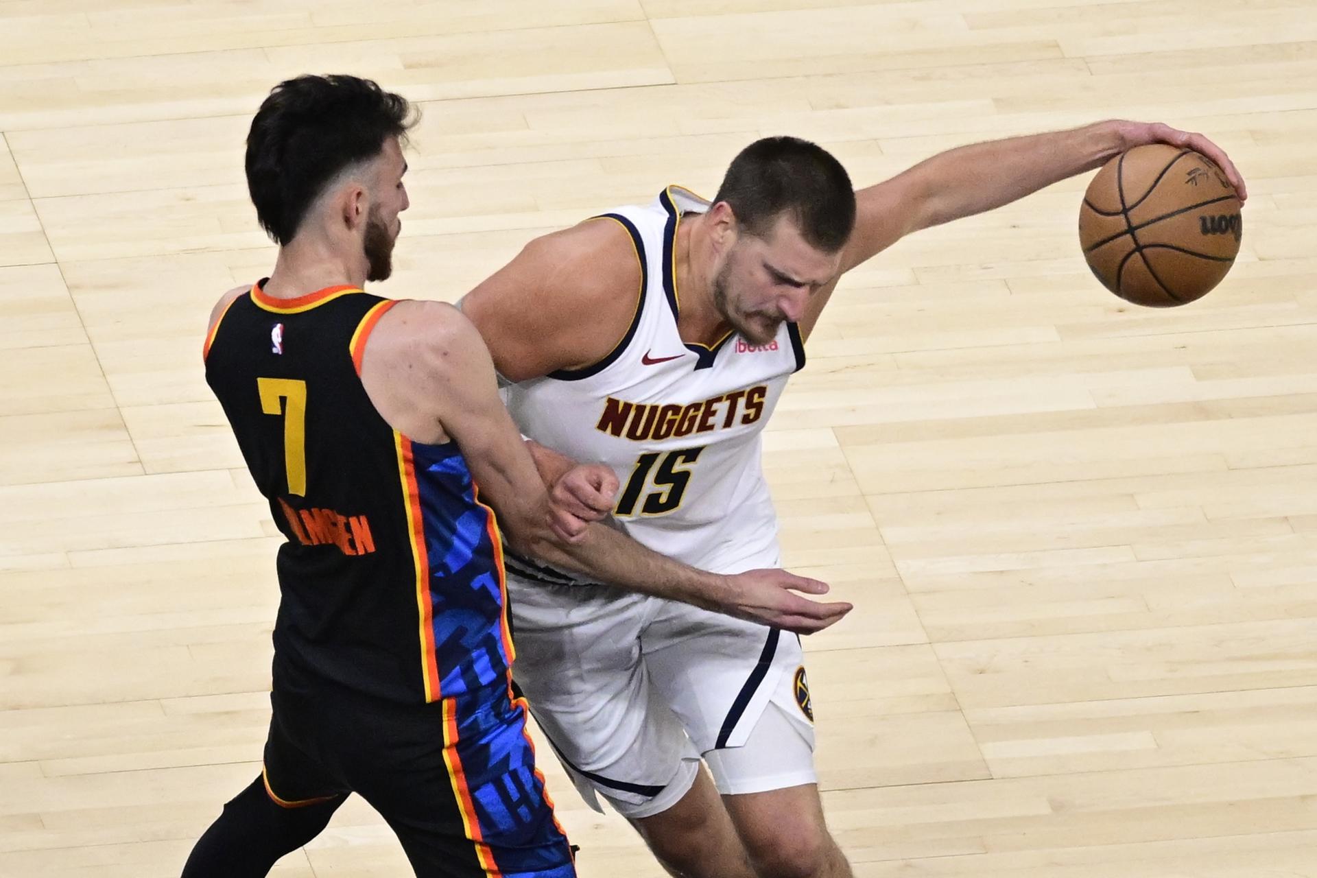 El pívot de los Nuggets Nikola Jokic (d) intenta sortear al alero de los Oklahoma City Thunder Chet Holmgren (i) durante el primer partido de las semifinales de la Conferencia Oeste que ganaron los de Denver por 119-121 y les deja con ventaja de 0-1 en la serie. EFE/EPA/GERALD LEONG