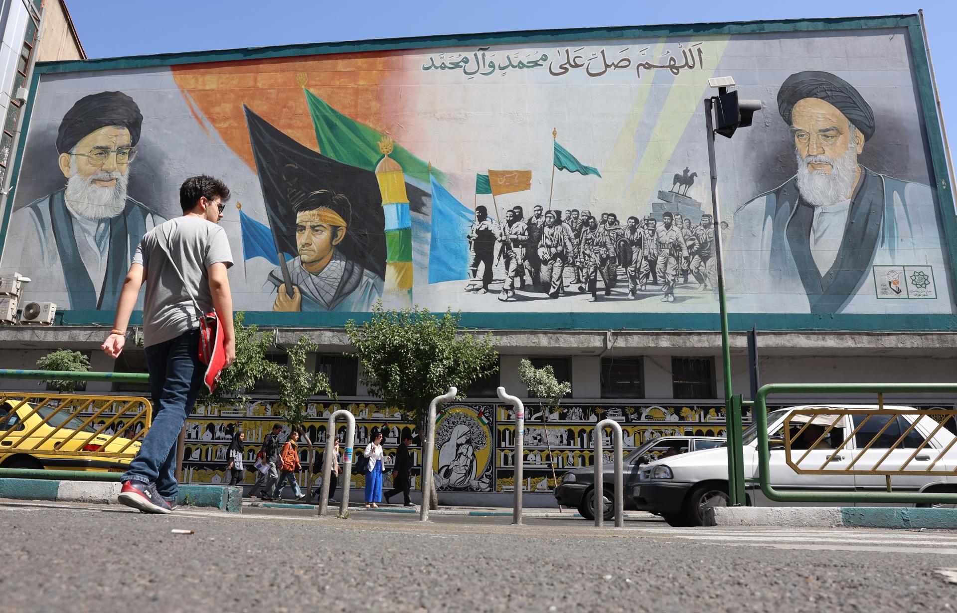 Iraníes caminan junto a una pintura mural del líder supremo iraní, el ayatolá Ali Jameneí (arriba-i) y el fallecido líder supremo iraní, el ayatolá Ruhollah Jomeiní (arriba-d), en una calle de Teherán. EFE/EPA/ABEDIN TAHERKENAREH
//////////
TEHRAN (IRAN(Islamic Republic Of)), 01/06/2025.- Iranians walk past a wall painting of Iranian supreme leader Ayatollah Ali Khamenei (Top-l) and late Iranian supreme leader Ayatollah Ruhollah Khomeini (Top-R) on a street in Tehran, Iran, 01 June 2025. In a joint statement on 31 May 2025, the Iranian Foreign Ministry and the Iranian Atomic Organisation condemned International Atomic Energy Organisation (IAEA) reports against Iran, adding that accusations regarding alleged undeclared sites and activities from decades ago were baseless, and that they had cooperated by providing access, samples and information on the alleged locations. (Teherán) EFE/EPA/ABEDIN TAHERKENAREH