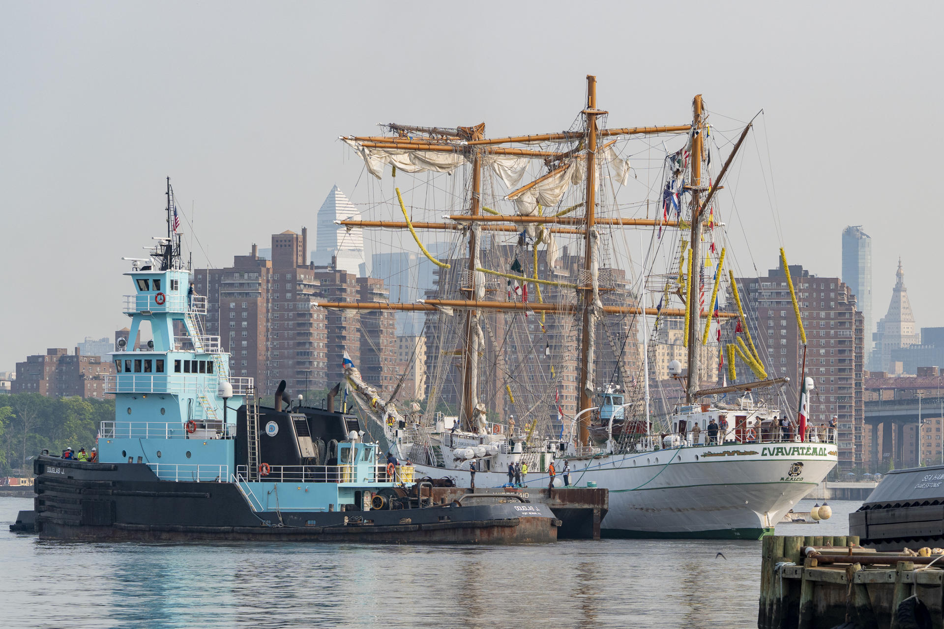 Personas participan en el traslado del buque escuela Cuauhtemoc, de la Armada Mexicana, desde el puerto 63 hasta Navy Yard, este viernes en Nueva York (EE.UU.). EFE/ Angel Colmenares