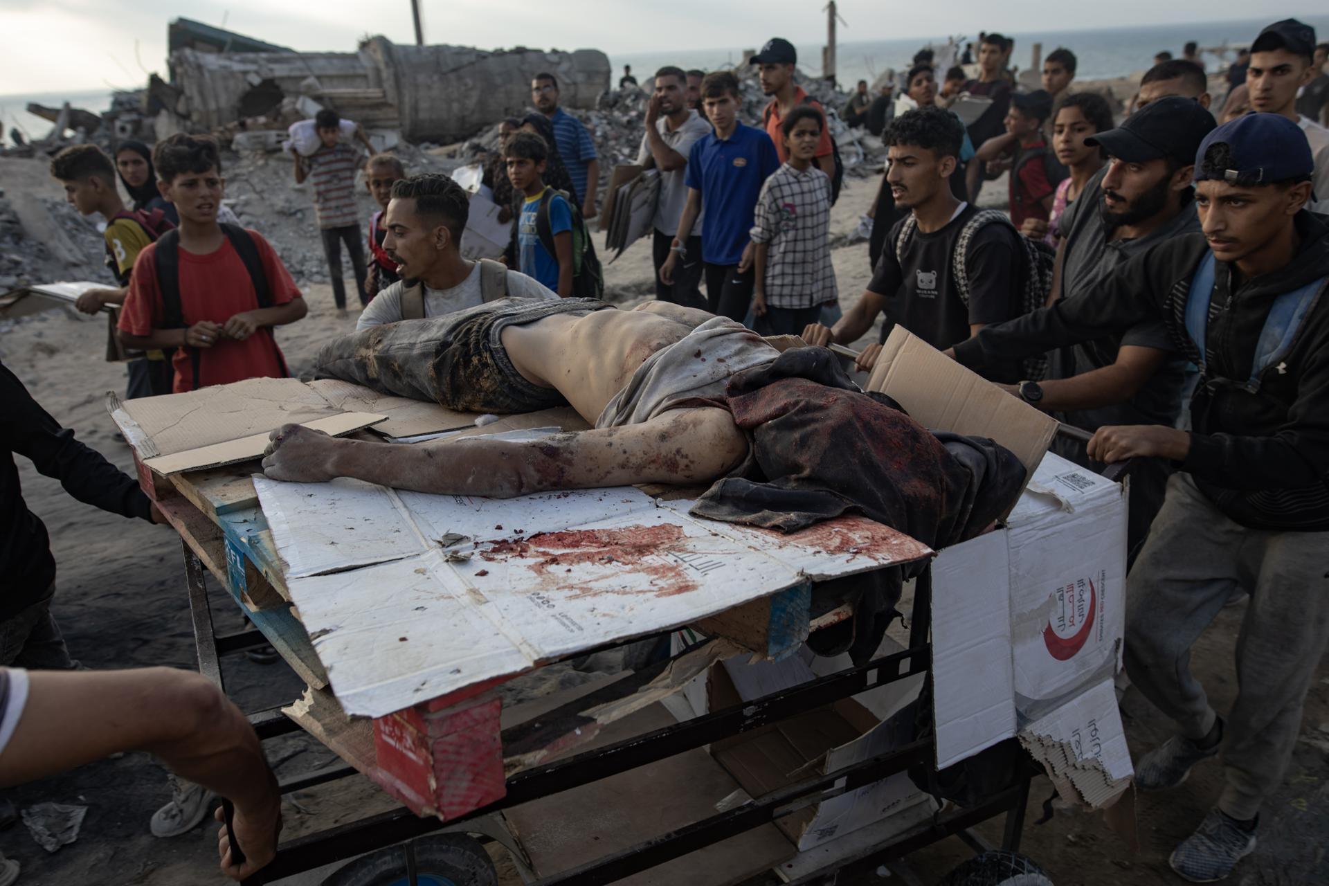 CONTENIDO GRÁFICO - Palestinos llevan el cuerpo de un hombre asesinado durante el fuego del ejército israelí mientras intentaba recolectar paquetes de alimentos, al oeste de Jabalia, en la Franja de Gaza norte, el 22 de junio de 2025.
EFE/EPA/HAITHAM IMAD -- ATTENTION EDITORS: GRAPHIC CONTENT