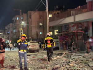 Integrantes de equipos de emergencia, bomberos y policía, trabajan en el área donde un proyectil iraní impactó provocando el derrumbe de un edificio en la madrugada de este domingo, en el Sur del Distrito Tel Aviv (Israel). EFE/ Magen David Adom MÁXIMA CALIDAD DISPONIBLE