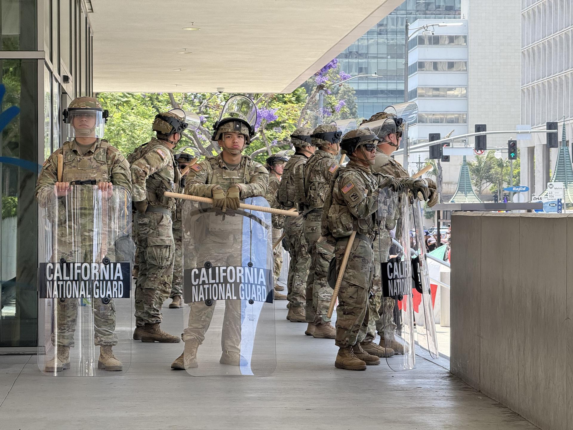 Integrantes de la Guardia Nacional de California esperan a la entrada de un edificio en el centro de Los Ángeles, California (EE.UU.). EFE/Alex Segura