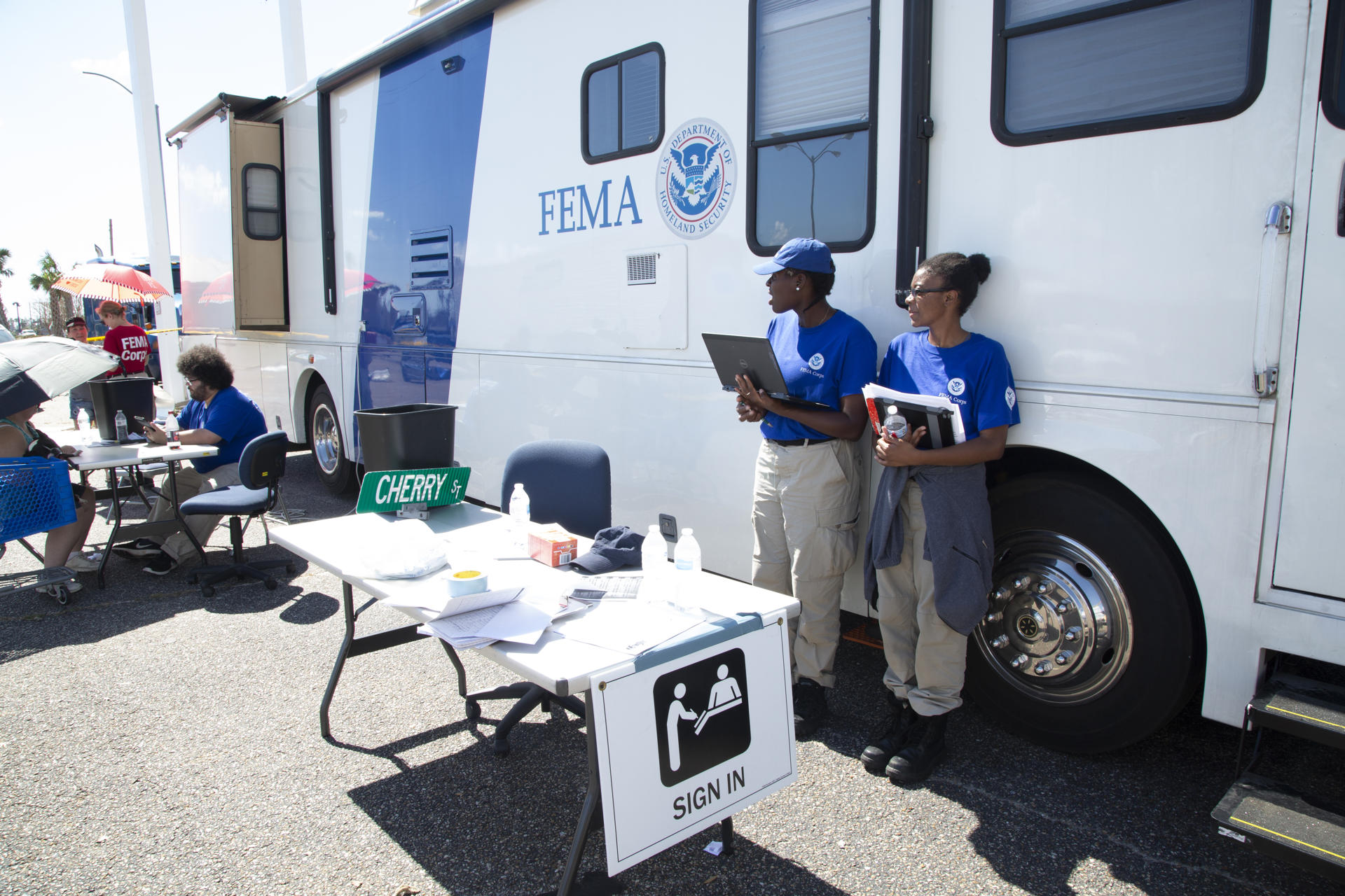Fotografía del 17 de octubre de 2018 cedida por la Agencia Federal de Gestión de Emergencias (FEMA) donde aparecen miembros de sus equipos de Asistencia para Sobrevivientes de Desastres (DSA) ayudando a los sobrevivientes a registrarse en los programas de afectados en las zonas afectadas por el huracán Michael en Panama City Beach, Florida (EE.UU.). EFE/Andrea Serhan/FEMA