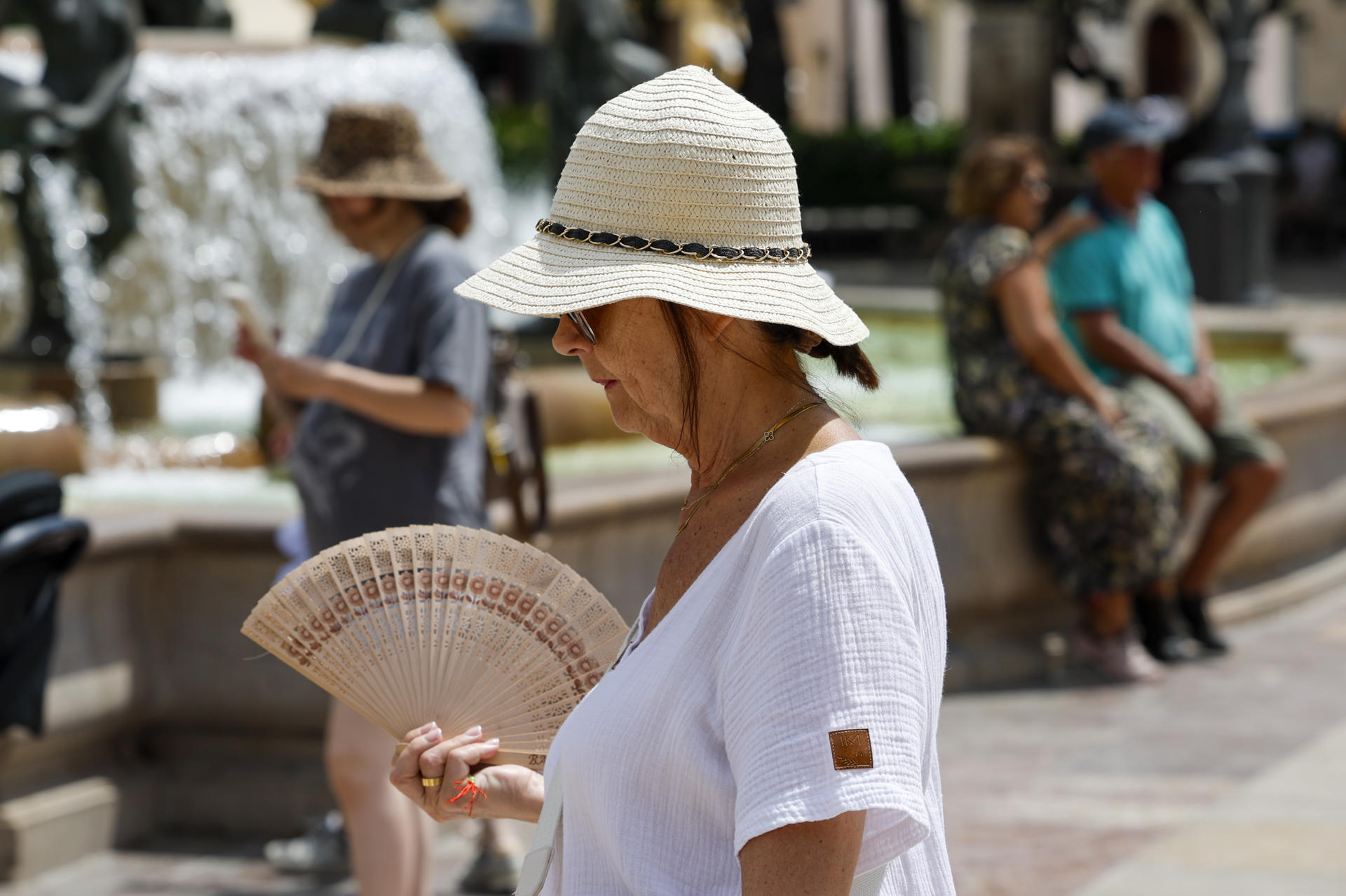 Una mujer se protege del sol y calor con sombrero y abanico den Valencia. EFE/Ana Escobar