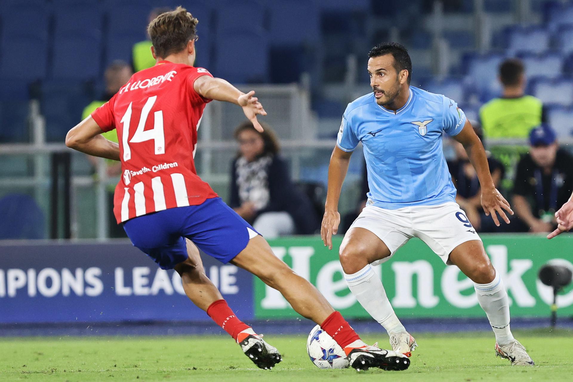 El delantero del Lazio Pedro Rodríguez trata de regatear a Marcos Llorente, del Atlético de Madrid. EFE/EPA/FEDERICO PROIETTI