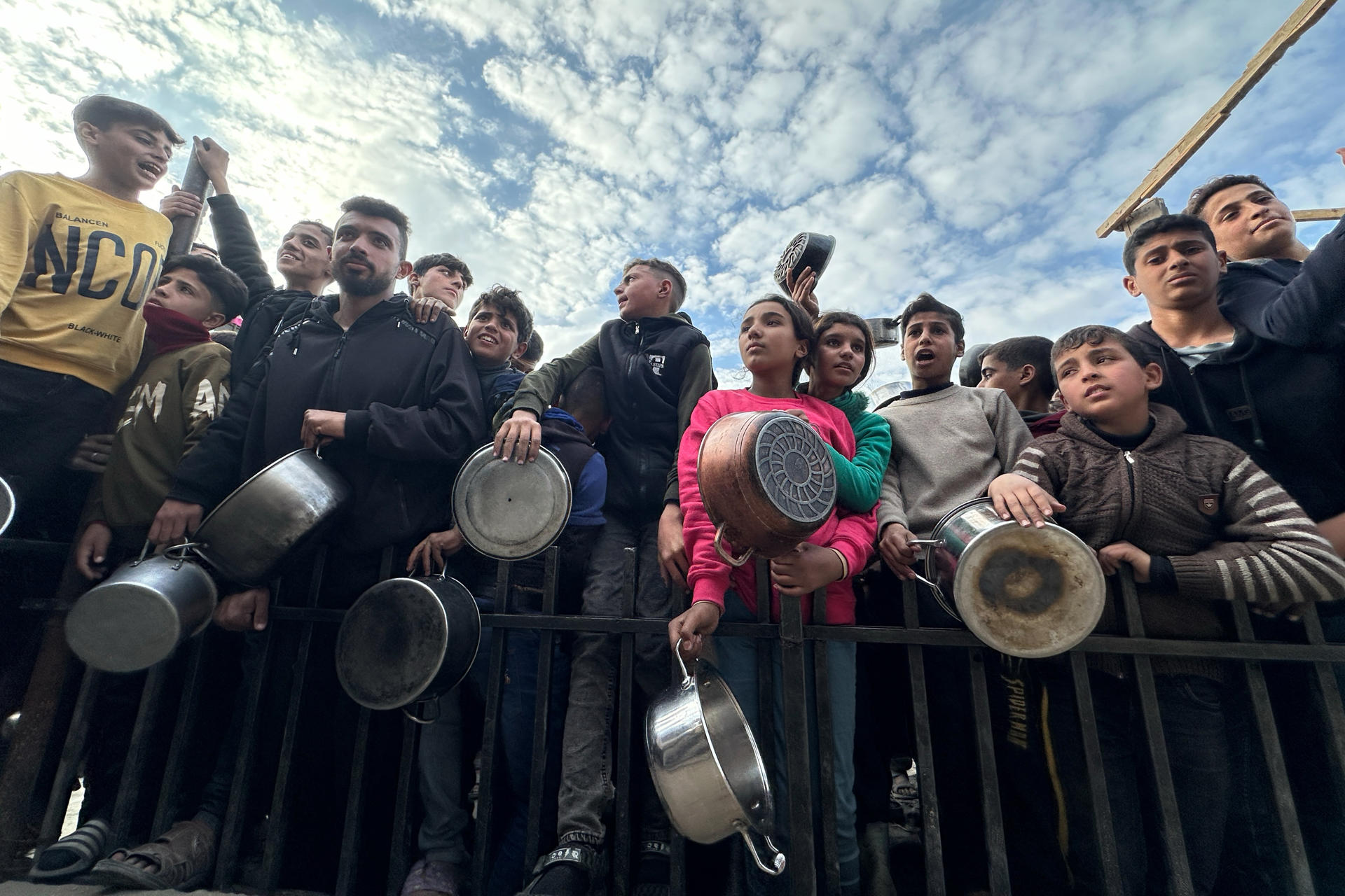 Decenas de niños se agolpan frente a un centro de ayuda, instalado en una tienda de campaña en medio de edificios derruidos en Gaza el 11 de marzo de 2025. EFE/Gaza