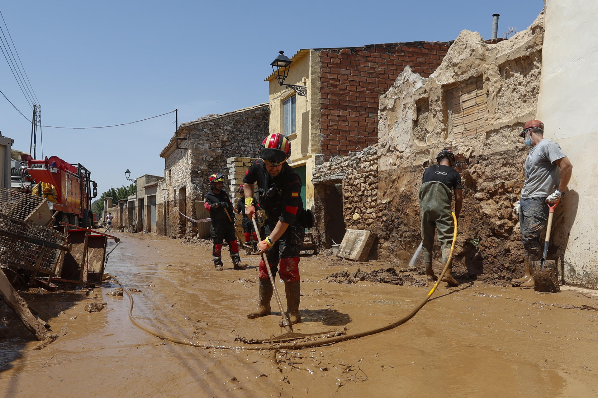 Vecinos y efectivos de la Unidad Militar de Emergencias (UME) en labores de limpieza en la localidad zaragozana de Azuara, una de las más golpeadas por las inundaciones que han provocado las lluvias. EFE/ Javier Belver