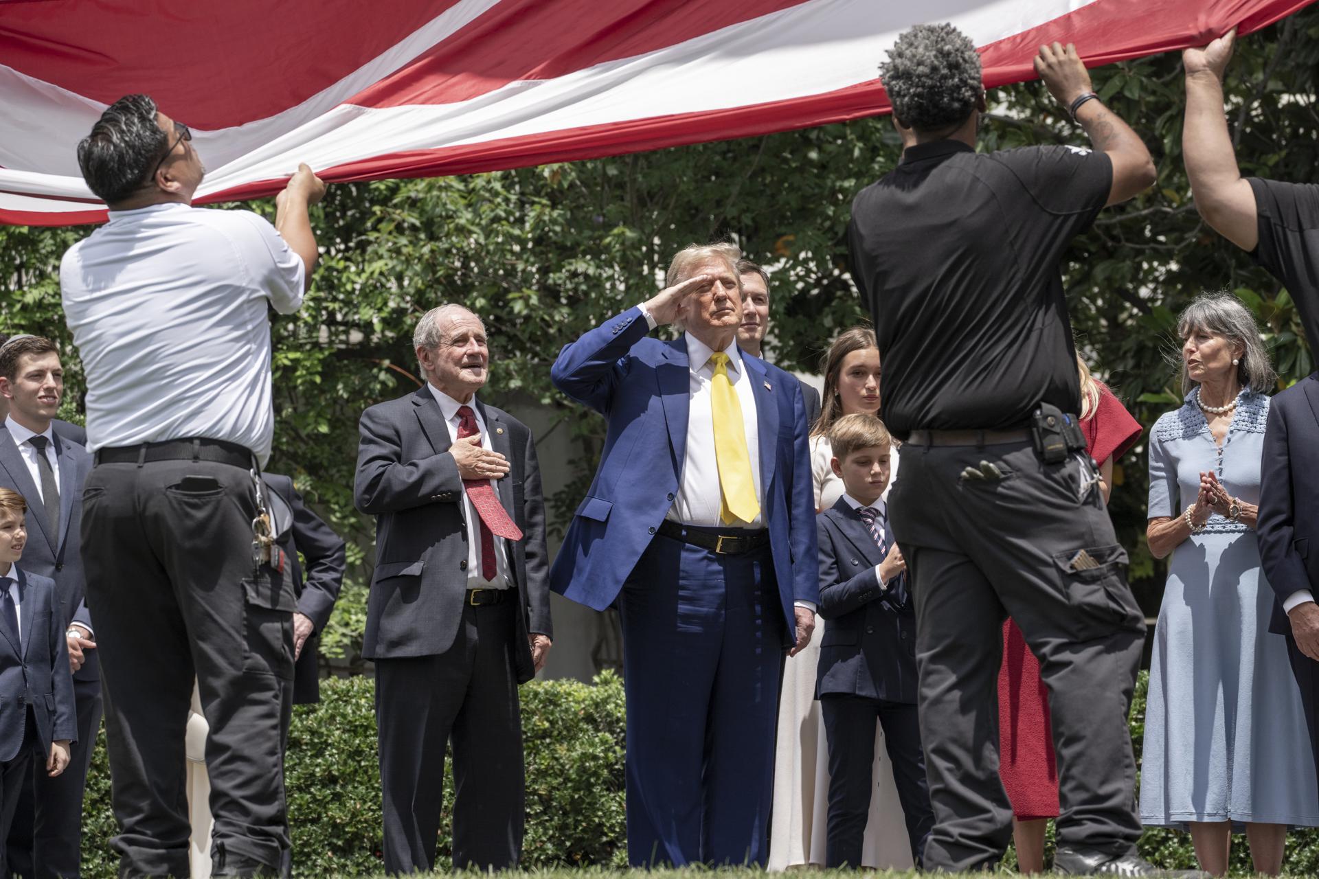 El presidente estadounidense, Donald Trump (C), saluda mientras la bandera estadounidense se iza por primera vez en el nuevo asta de bandera en el jardín sur de la Casa Blanca, en Washington, DC, EE. UU. EFE/EPA/KEN CEDENO / POOL
