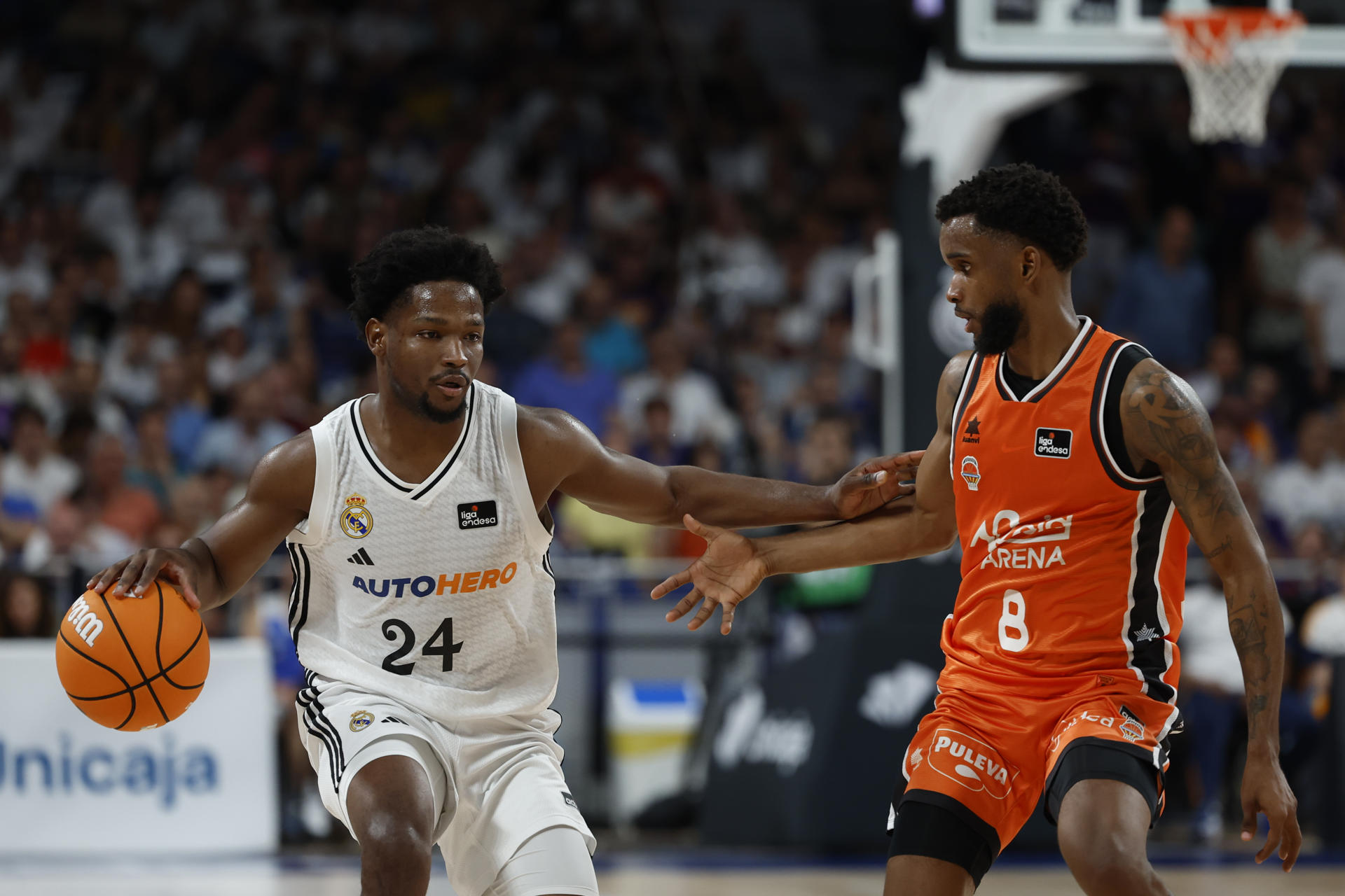 El base dominicano del Real Madrid Andrés Feliz (i) lucha con su compatriota Jean Montero, del Valencia Basket, durante el segundo partido de la final de la Liga Endesa que Real Madrid y Valencia Basket disputaron en el Movistar Arena, en Madrid. EFE/ Mariscal