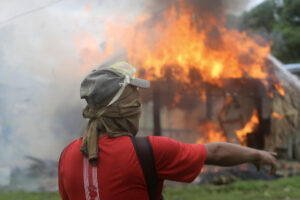 Una persona se enfrenta con integrantes de la Policía de Panamá, durante una manifestación contra la reforma a la seguridad social este jueves, en Arimae (Panamá). EFE/ Carlos Lemos