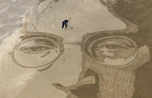 El arte efímero del peruano Germán Cedano se borra con la marea. Sus monumentales dibujos sobre la arena transforman la playa de La Concha de San Sebastián en un lienzo en el que este artista callejero graba retratos, mandalas y mensajes que se viralizan en redes y que, pese a su repercusión, nunca repite. En la imagen trabaja en un retrato del músico John Lennon creado en la playa de Itzurun de Zumaia (Gipuzkoa). EFE/Juan Herrero.