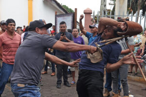 Personas se dan latigazos durante el tradicional baile de 'Los Chinegros' en honor a San Juan Bautista este martes, en San Juan de Oriente (Nicaragua). EFE/ STR