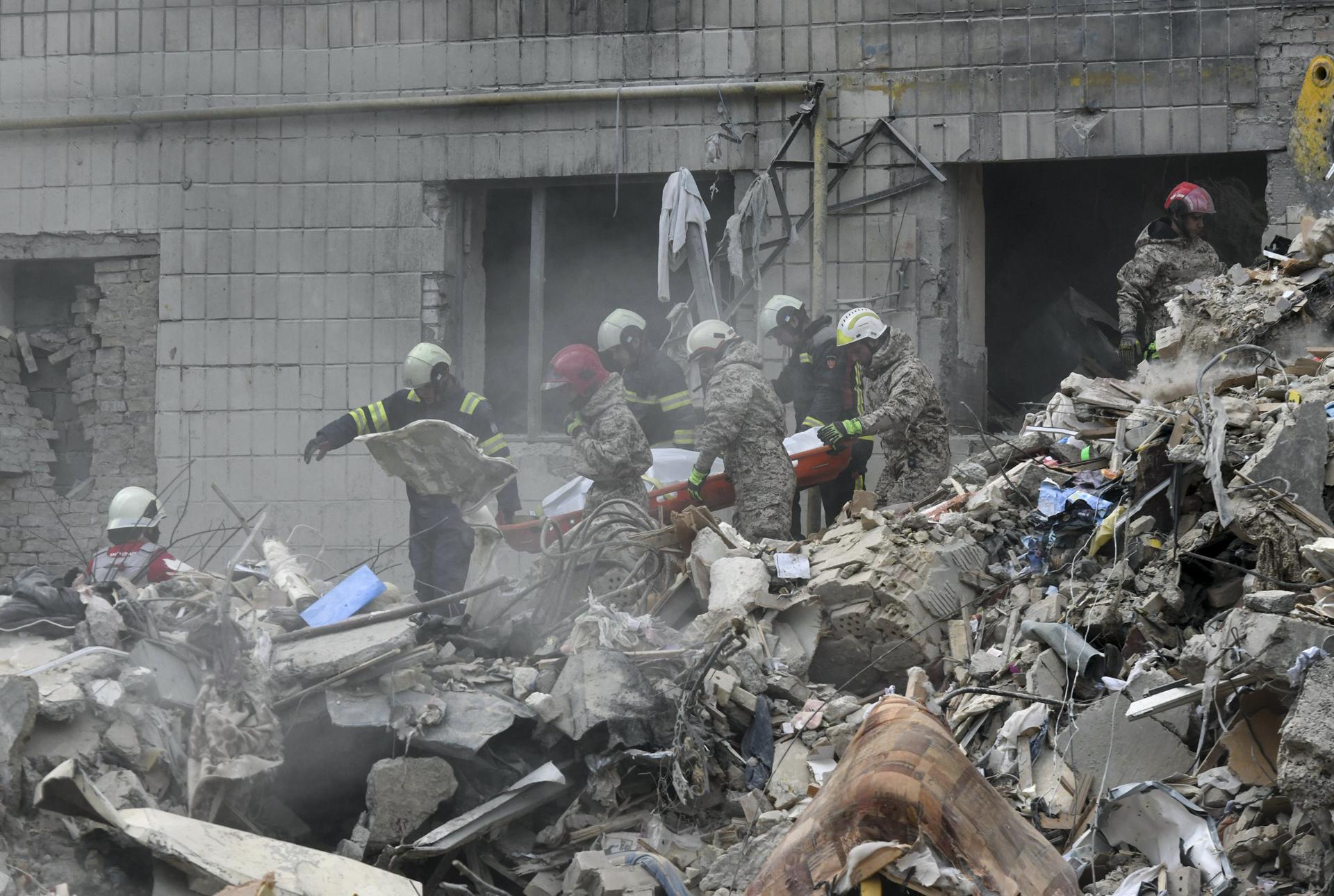 Rescatistas ucranianos fueron captados este martes, 17 de junio, al trasladar el cuerpo de una víctima fatal de un ataque aéreo ruso nocturno contra un edificio residencial de nueve pisos, en Kiev (Ucrania) EFE/Maxym Marusenko