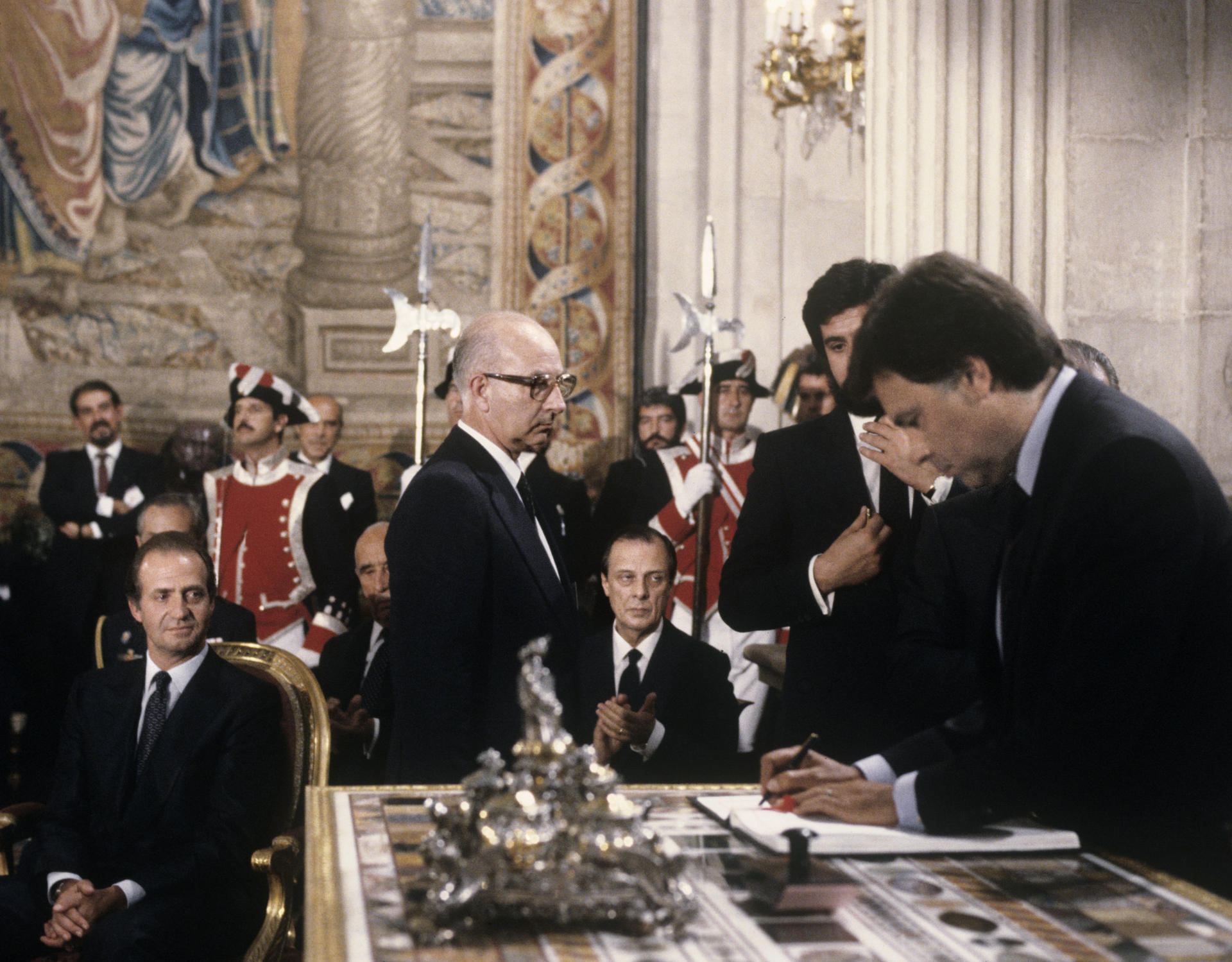 El presidente del Gobierno español, Felipe González, firma el Tratado de Adhesion de España a la CEE, ante la atenta mirada del rey Juan Carlos I, el marqués de Mondejar y Sabino Fernández Campo, durante la ceremonia celebrada en el salón de Columnas del Palacio Real. EFE/Manuel Hernández de León/aa.
SPAIN AGREEMENT EEC: MADRID, 12/06/1985.- The Spanish Prime Minister, Felipe González, signed the Treaty of Accession of Spain to the EEC, under the watchful eye of King Juan Carlos I, the Marquis de Mondejar and Sabino Fernández Campo, during the ceremony in the Hall of Columns of the Royal Palace. EFE/Manuel Hernández de León
