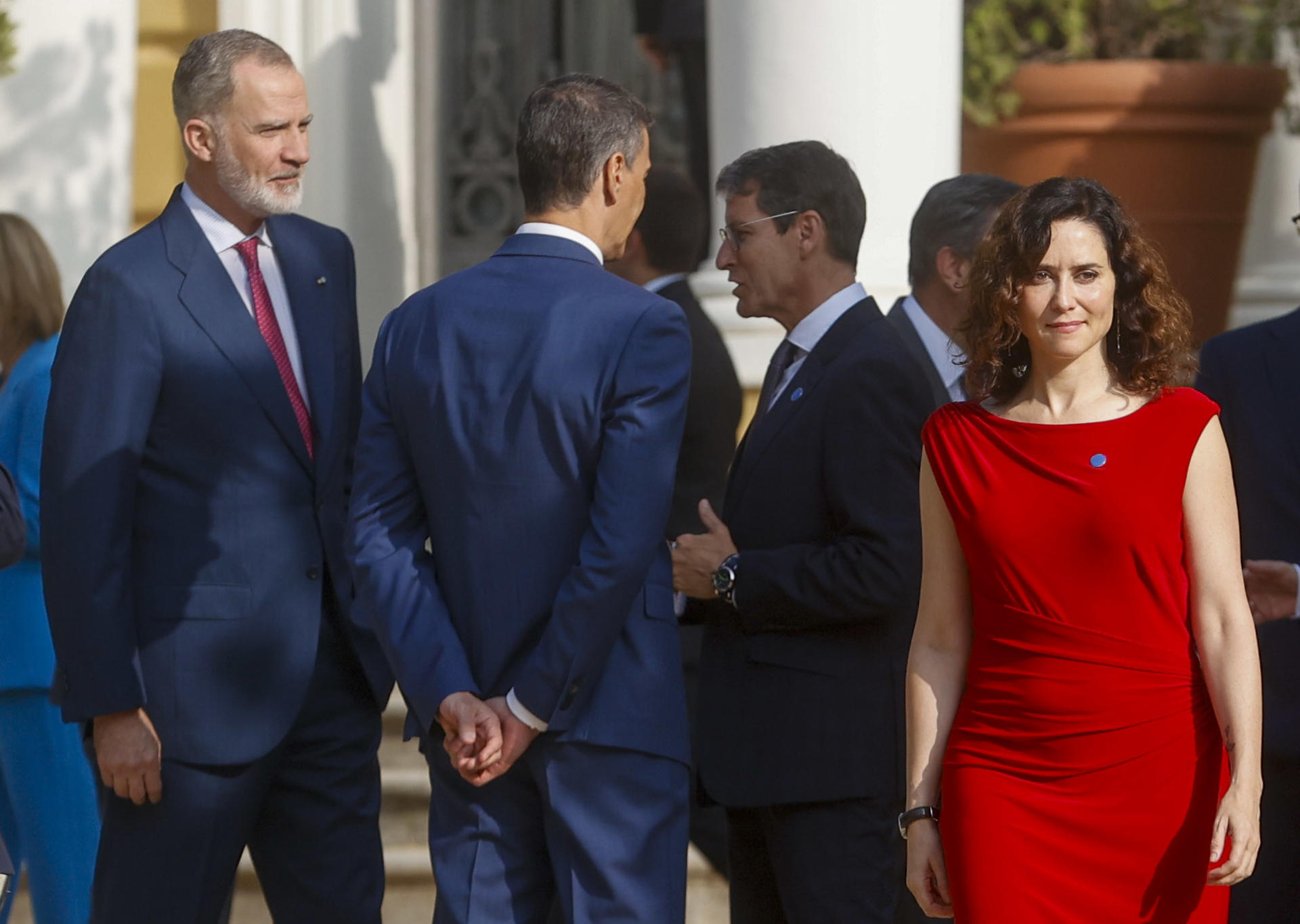 La presidenta de la Comunidad de Madrid, Isabel Díaz Ayuso, pasa junto al rey Felipe VI y el presidente del Gobierno, Pedro Sánchez (2i), que conversan con el presidente de La Rioja, Gonzalo Capellán (2d), a su llegada a la XXVIII Conferencia de Presidentes que se celebra este viernes en el Palau de Pedralbes, en Barcelona. EFE/ Quique García