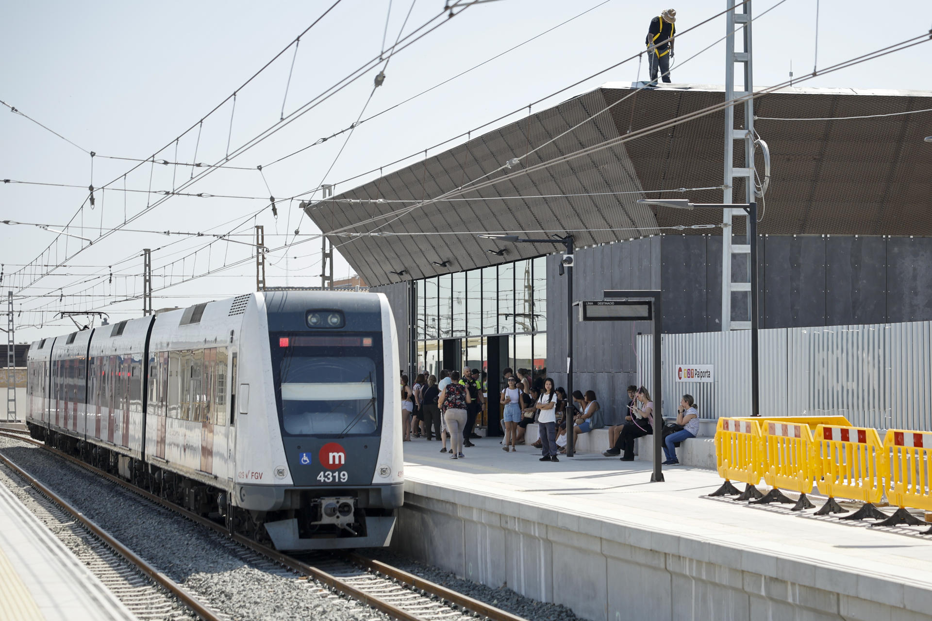 Varias personas aguradan en la estación de Paiporta este viernes en el que entra en funcionamiento el tramo València Sud-Castelló de Metrovalencia, en la zona cero de la dana, ocho meses después de las inundaciones y tras los trabajos de reconstrucción que han tenido un presupuesto de 140 millones de euros. EFE/Biel Aliño
