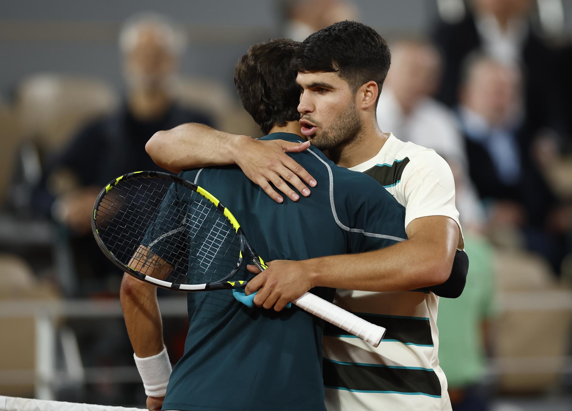 El español Carlos Alcaraz, número dos del mundo y defensor del título, se abraza a su rival, el italiano Lorenzo Musetti, después de que este se retirara del partido de semifinales de Roland Garros. EFE/YOAN VALAT