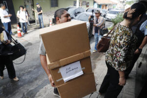 Una persona que traslada cajas con expedientes llega al juicio por el crimen de varios periodistas holandeses, en Chalatenango (El Salvador). EFE/ Rodrigo Sura