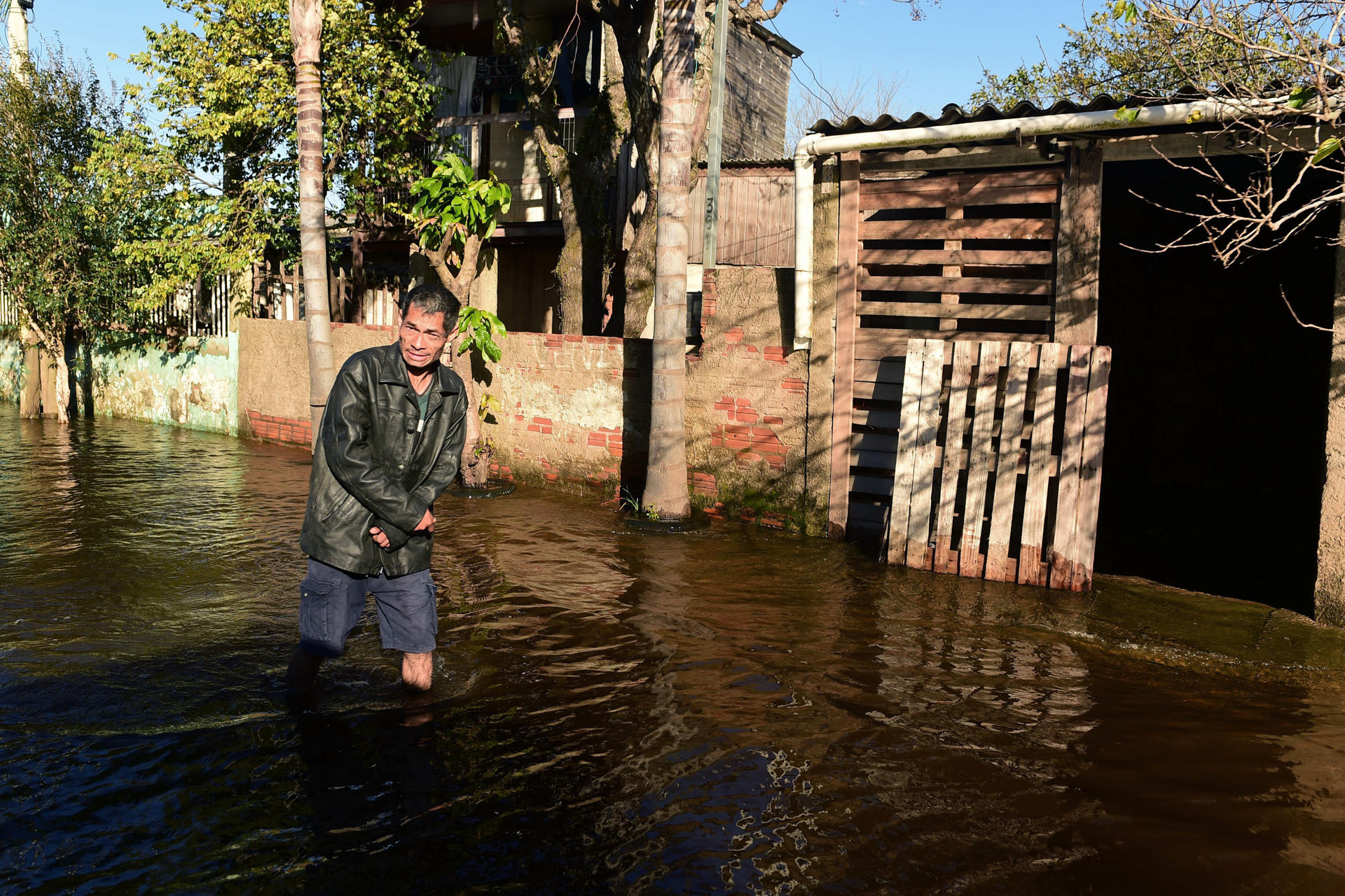 Un hombre camina por una calle tras el desbordamiento del río Guaíban que inundó una sección de la costa este lunes, en Porto alegre (Brasil). EFE/ Ricardo Rimoli.
