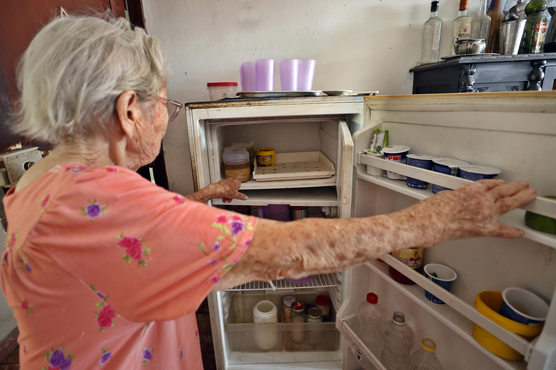 Teresa García, una mujer cubana de 94 años, muestra el interior de su refrigerador en su casa en Pinar del Río (Cuba). EFE/ Ernesto Mastrascusa
