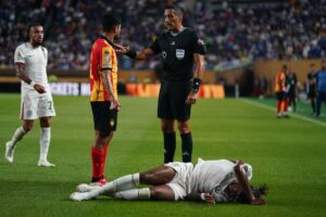 Mohamed Benali, de Esperánce Tunis (2-i), es reconvenido por el árbitro tras agredir a Reece James del Chelsea (abajo) durante el partido de la última jornada del Mundial de Clubes que ha clasificado al equipo inglés a los octavos de final este martes en Filadelfia (Pensilvania). EFE/EPA/WILL OLIVER