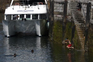 Unos jóvenes se bañan en el puerto pesquero de San Sebastián. EFE/Juan Herrero.