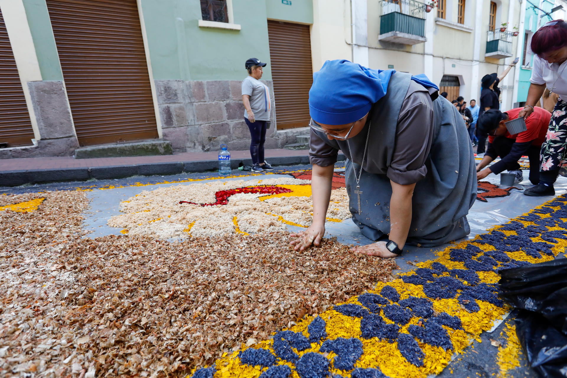 Una persona trabaja sobre una alfombra de flores exhibida este sábado, en la ciudad de Quito (Ecuador). EFE/ Santiago Fernández