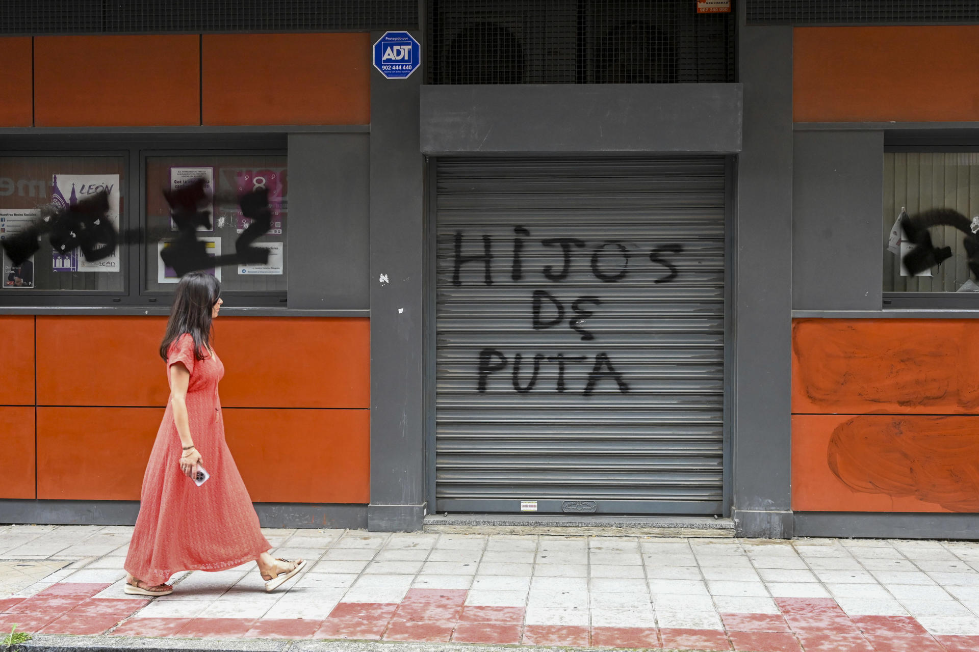 Una mujer pasa ante la fachada de la sede del PSOE de León que este jueves ha sufrido pintadas con insultos y rotura de cristales. El secretario del PSOE en León, Javier Alfonso Cendón, ha condenado el ataque que ha sufrido la sede del partido en León capital y ha asegurado que "ninguna violencia ha doblegado ni doblegará jamás su lucha" y ha pedido al PP que lo condene. EFE/ J.Casares
