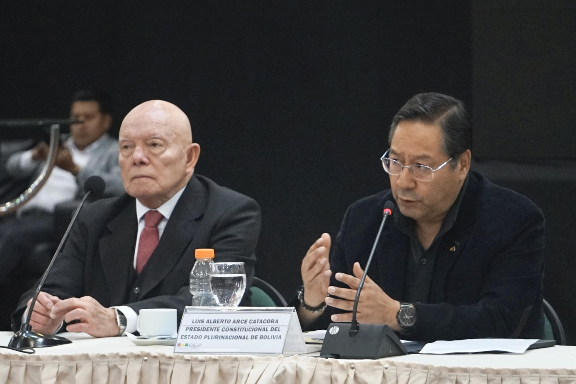 El presidente del Tribunal Supremo Electoral (TSE) de Bolivia, Óscar Hassenteufel (i), y el presidente de Bolivia, Luis Arce, hablan durante la inauguración del IV Encuentro Multipartidario e Interinstitucional por la Democracia este jueves, en Santa Cruz (Bolivia). EFE/ Juan Pablo Roca