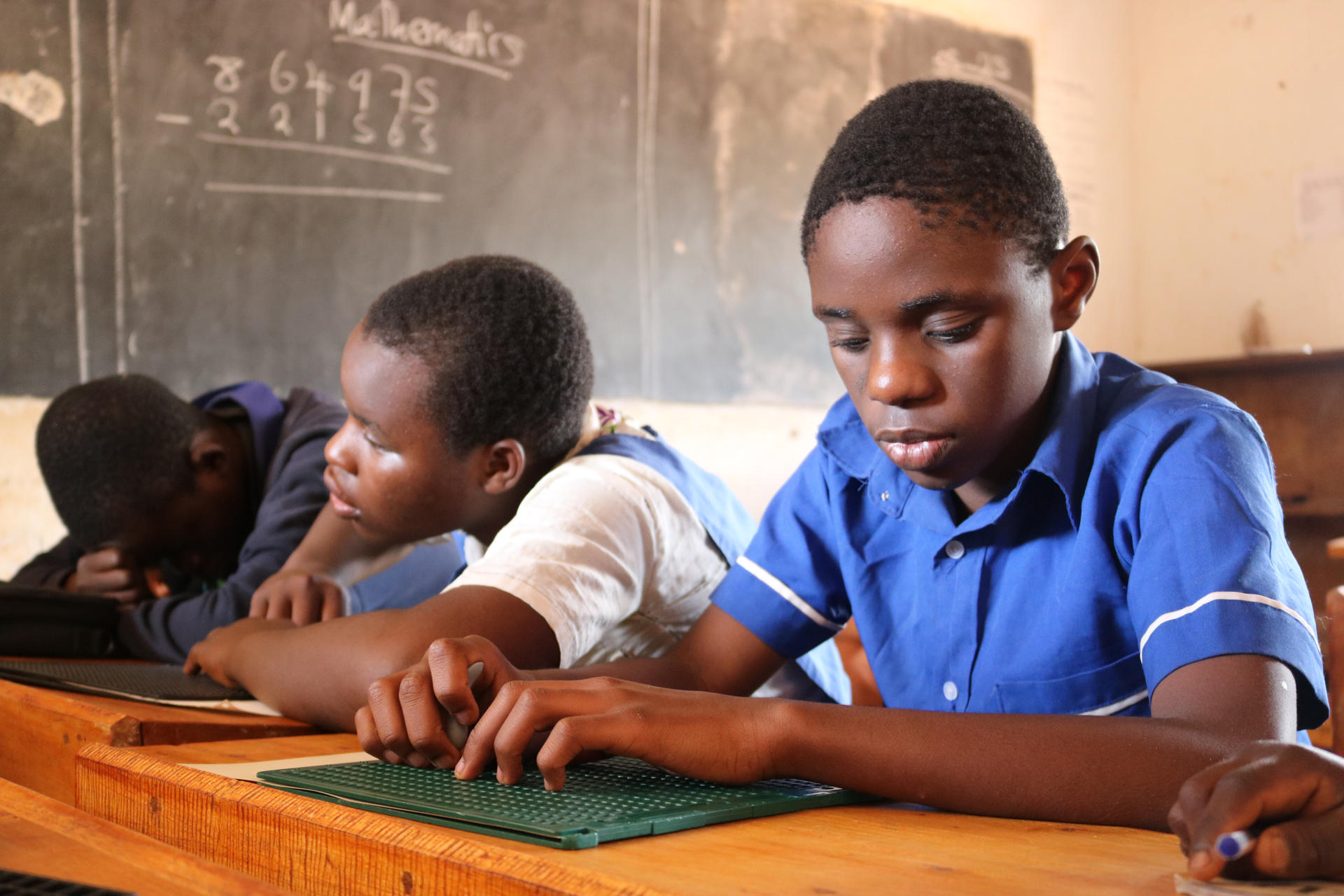 Estudiantes durante una clase de matemáticas utilizan materiales adaptados para su aprendizaje. En el corazón del distrito de Kasungu, una región del centro de Malaui golpeada por el cambio climático y el hambre, se alza una escuela única: el Colegio Chilanga para Ciegos, un refugio de aprendizaje y esperanza para niños y niñas con discapacidad visual y albinismo. EFE/Paula García Ajofrin