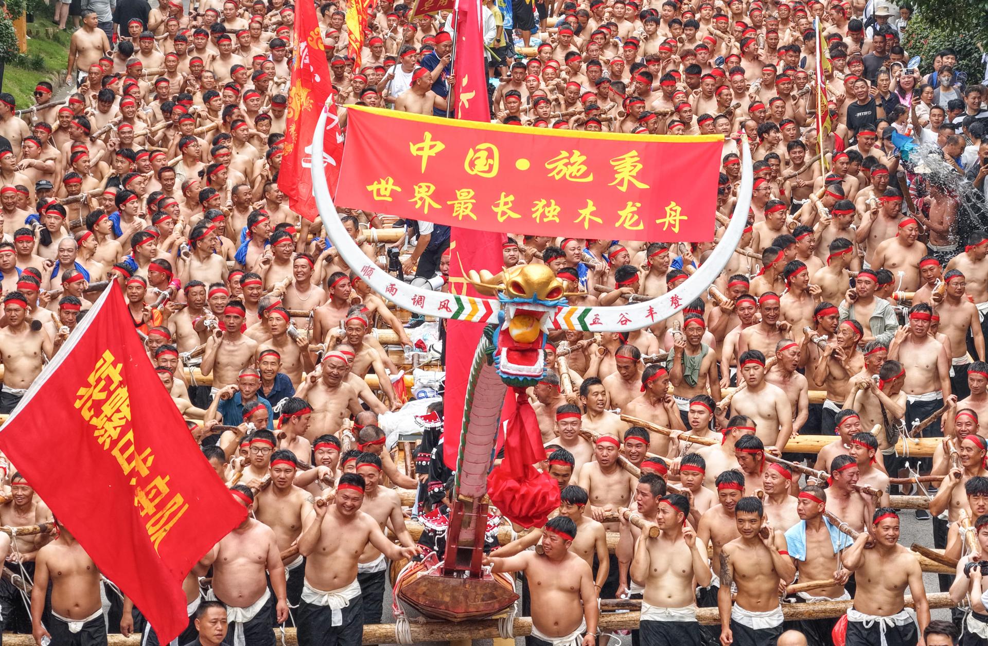 Numerosas personas cargan un bote dragón extra largo durante un desfile en celebración del Festival del Bote del Dragón en el condado de Shibing, suroeste de la provincia de Guizhou, China, el 31 de mayo de 2025. EFE/EPA/XINHUA / MO GUIBIN CHINA OUT / UK AND IRELAND OUT / USO EDITORIAL DE CRÉDITO OBLIGATORIO