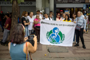 Personas sostienen una pancarta del movimiento 'Madres en defensa de la verdad', este miércoles en inmediaciones de los tribunales del Palacio de Justicia en Caracas (Venezuela). EFE/ Miguel Gutierrez