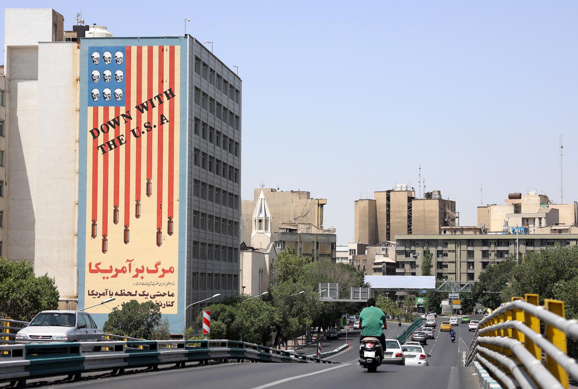 Tráfico junto a un edificio con un mural antiestadounidense en Teherán, Irán, el 22 de junio de 2025. EFE/EPA/ABEDIN TAHERKENAREH
