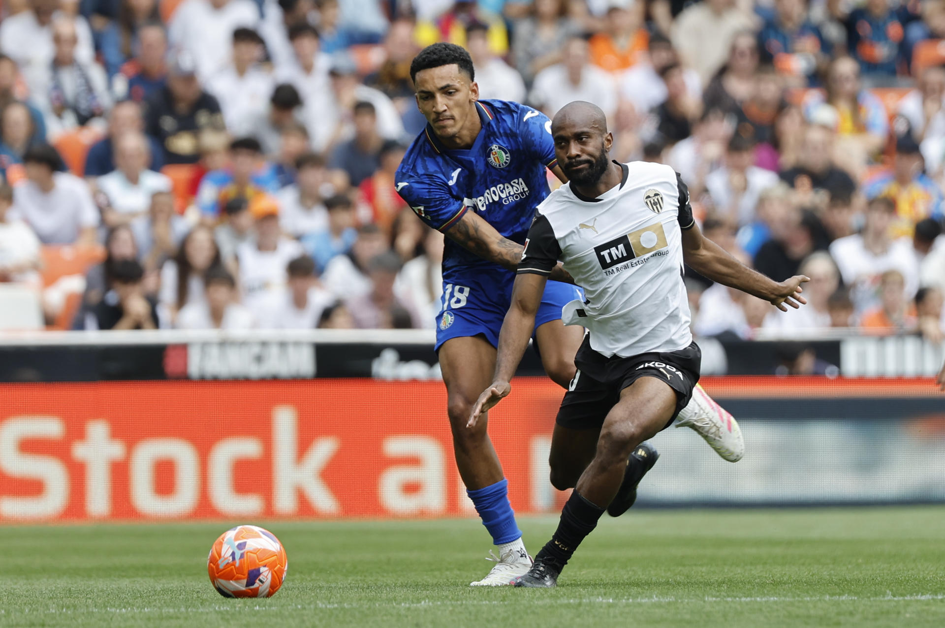 El defensa del Valencia Dimitri Foulquier (d) disputa el balón ante el delantero del Getafe Álvaro Rodríguez durante un partido de LaLiga EA Sports disputado en el Estadio de Mestalla en Valencia. EFE/Ana Escobar