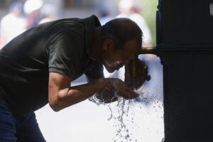Un hombre se refresca en una fuente en Barcelona este sábado. Catorce comunidades están este sábado en alerta por temperaturas excepcionalmente altas en el día de inicio de la primera ola de calor del verano en España. EFE/Quique García