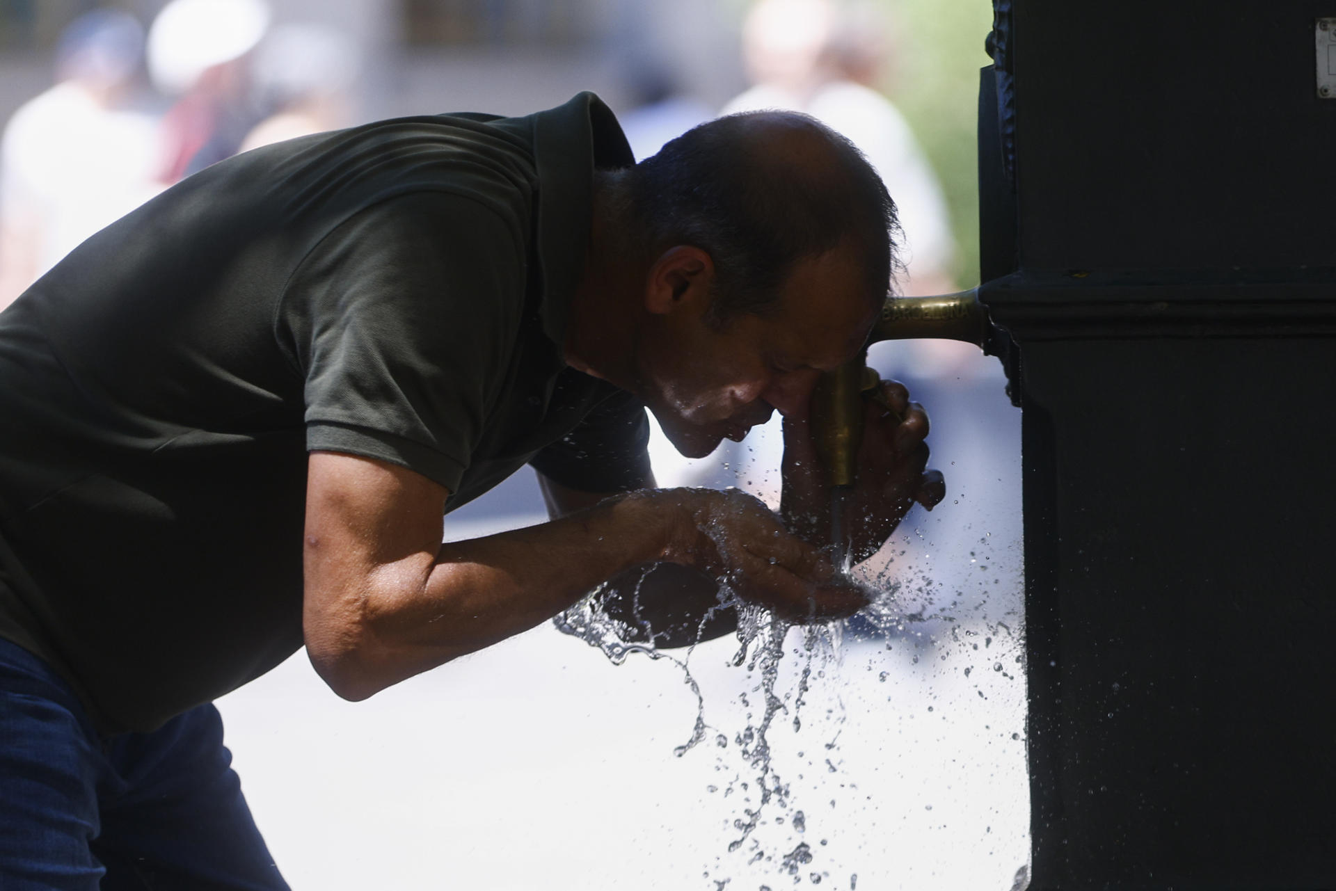Un hombre se refresca en una fuente en Barcelona este sábado. Catorce comunidades están este sábado en alerta por temperaturas excepcionalmente altas en el día de inicio de la primera ola de calor del verano en España. EFE/Quique García