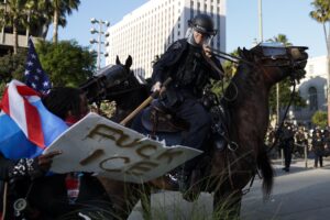 Oficiales del Departamento de Policía de Los Ángeles se enfrentan este miércoles con manifestantes frente al Ayuntamiento de Los Ángeles (EE.UU.). EFE/EPA/CAROLINE BREHMAN
