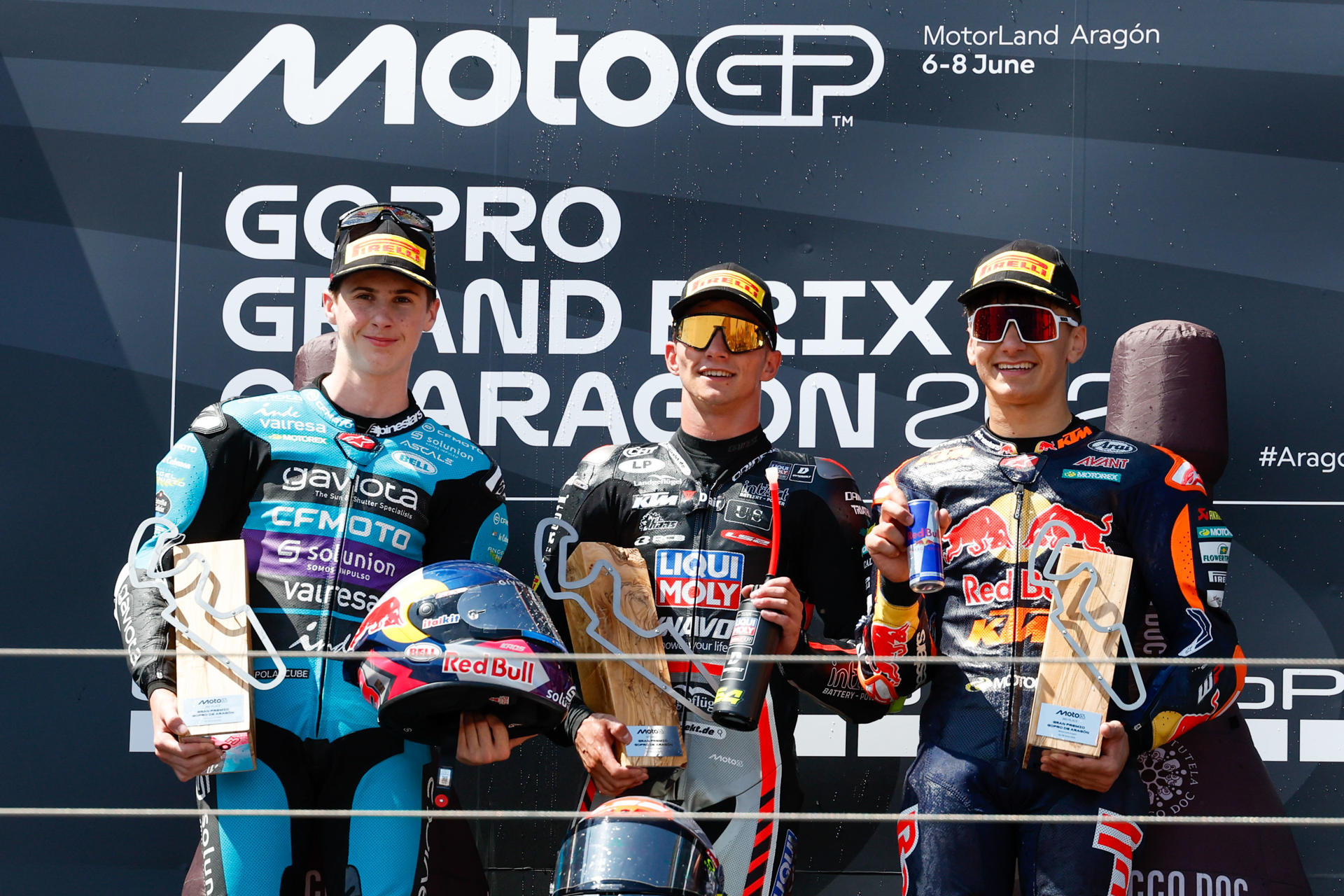 El piloto español de Moto3 David Muñoz (c), del equipo Dynavolt Intact GP, celebra en el podio su victoria en la carrera de Moto3 del Gran Premio de Aragón de MotoGP en el circuito Motorland de Alcañiz acompañado por sus compatriotas Máximo Quiles (i), del equipo Ángel Nieto Team, que finalizó en segunda posición y Álvaro Carpe (Red Bull KTM Ajo), que fue tercero. EFE/Javier Cebollada