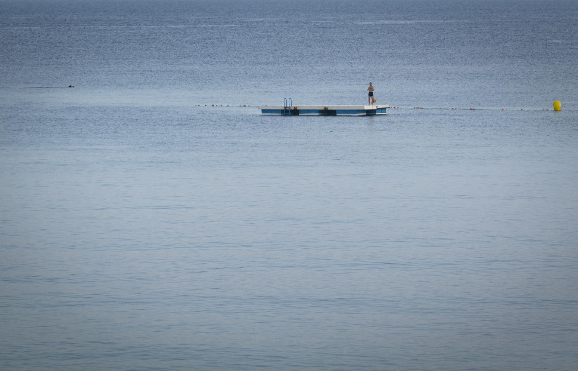 Un bañista descansa en uno de los gabarrones de la playa de Ondarreta de San Sebastián, en una fotografía de archivo. EFE/Javier Etxezarreta
